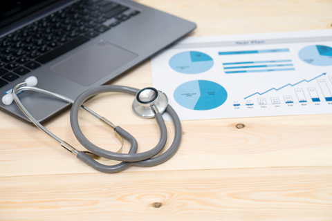 Computer, stethoscope and chart indicating allocation toward healthcare stocks